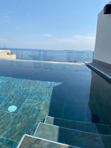 a swimming pool with a view of the water at Akrogiali Apartments in Barbati
