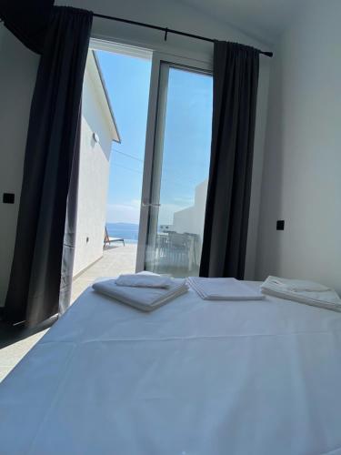 a bedroom with a bed with a view of the ocean at Akrogiali Apartments in Barbati