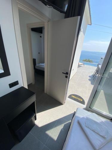 a room with a door and a view of the ocean at Akrogiali Apartments in Barbati