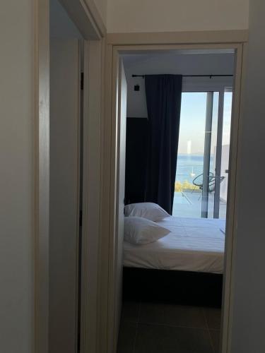 a bedroom with a bed and a view of the ocean at Akrogiali Apartments in Barbati