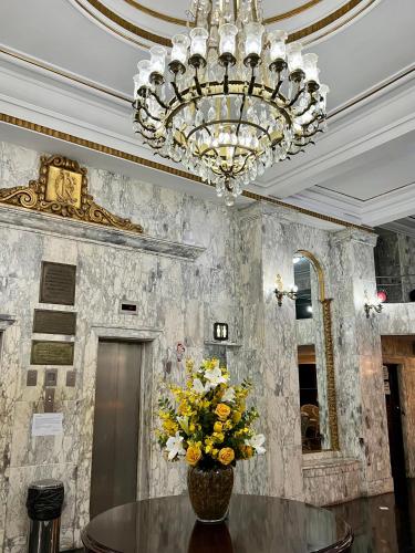 a dining room with a chandelier and a table with flowers at Hotel OK in Rio de Janeiro