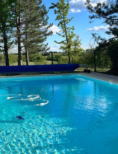 une piscine avec de l'eau bleue dans une cour dans l'établissement Les Hauts de Courrech, à Grézels