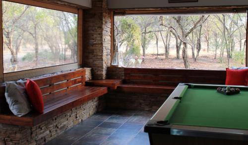 a room with a pool table in front of two windows at Foreva Wild in Klipdrift