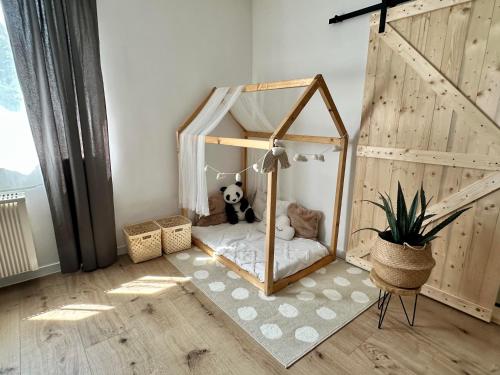 a stuffed panda bear sitting in a bed in a room at Apartmány Zahražany in Most