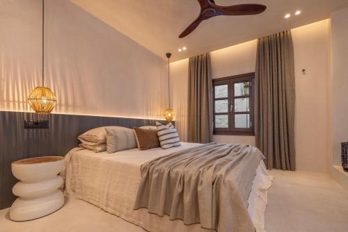 a bedroom with a bed and a ceiling fan at Kantouni Lindos ELEGANT APARTMENT in Líndos