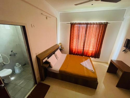 baño pequeño con cama y ducha en B SIX HOTEL, en Bangalore