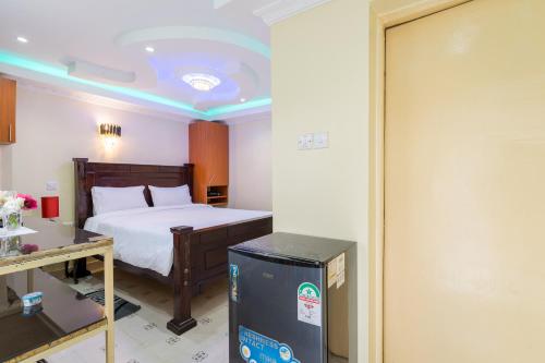 Un dormitorio con una cama, una mesa y un frigorífico. en East of Eden, en Nairobi