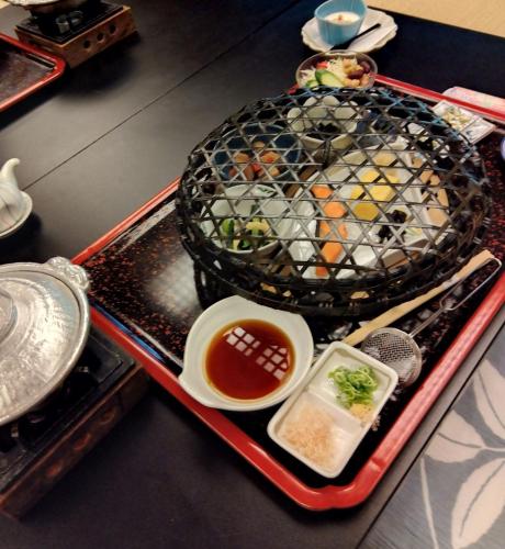 京都市にある日昇別荘の食べ物の入ったケージとスープの入ったボウルが載ったトレイ