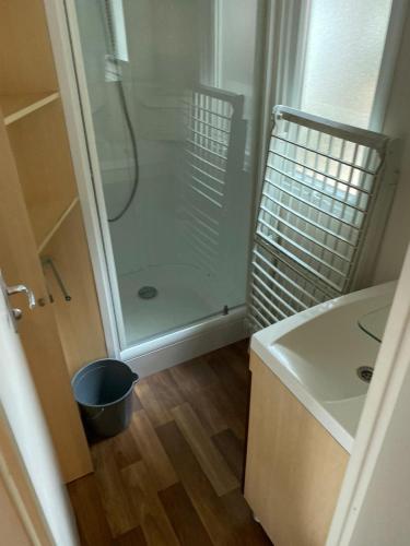 une salle de bain avec douche et lavabo dans l'établissement Mobil-home au Camping familial 4 étoiles Les Sables d'Or, au Cap d'Agde