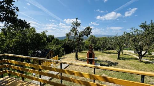 a wooden fence with a fire hydrant in a field at IezerVenture Cabins - ChiangMai in Şelari