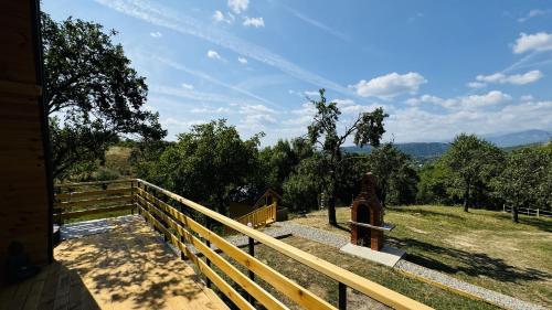 a wooden balcony with a view of a field at IezerVenture Cabins - ChiangMai in Şelari