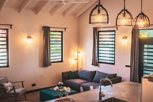 a living room with a couch and windows at Villa 5 Green Courtyard Village in Kralendijk