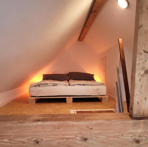 a bedroom with a bed in the attic at Modernes 1-Zimmer-Apartment mit Galerie-Schlafkoje im skandinavischen Stil in Ostenfeld