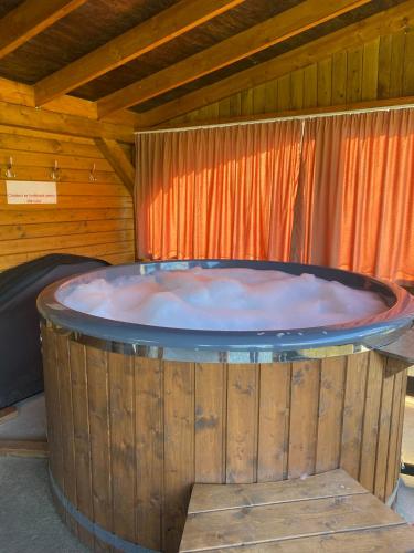 a large hot tub sitting in a room with a wooden ceiling at Cabana La Batranu-ciubar&atv in Borşa