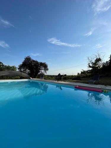 ein großer Pool mit blauem Himmel im Hintergrund in der Unterkunft Les chambres de Lagarrigue, soirée étape in Senouillac