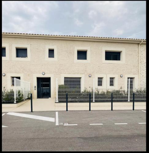 a white building with a fence in front of it at Appartement moderne proche de tout et parking gratuit in Lattes