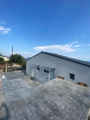 a large white building with a large parking lot at Akrogiali Apartments in Barbati