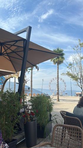 a patio with an umbrella and some plants and trees at Enzo Apartments in Vlorë