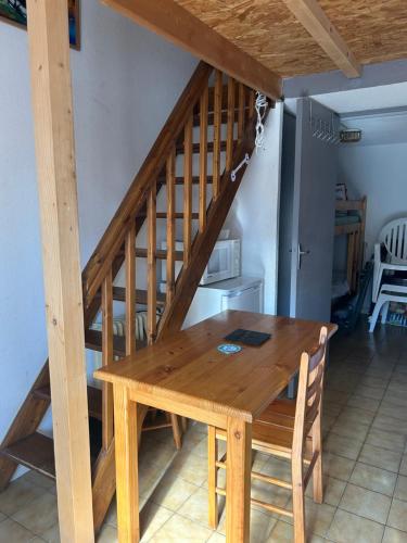 - une table en bois avec un escalier en bois dans l'établissement appartement village naturiste, à Leucate-Plage