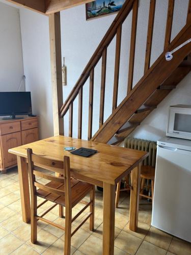 - une table et une chaise en bois dans une cuisine avec un escalier dans l'établissement appartement village naturiste, à Leucate-Plage
