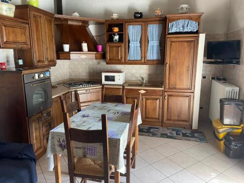 a kitchen with wooden cabinets and a table and a table and chairs at Agriturismo Oddone in Bardineto