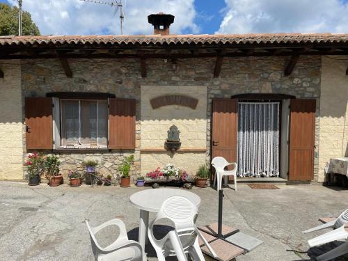 a patio with a table and chairs in front of a house at Agriturismo Oddone in Bardineto