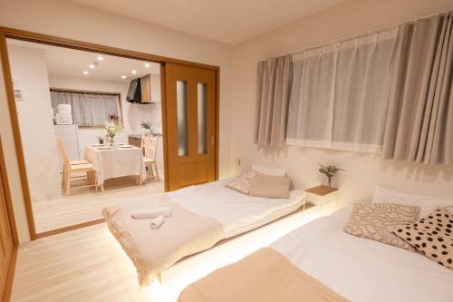 a room with two beds and a dining room at Six7 APT三ノ輪 in Tokyo