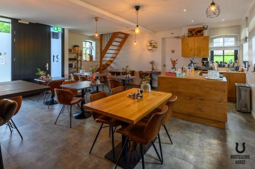 a restaurant with a wooden table and chairs at Hostellerie Horst in Horst