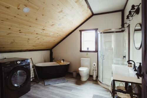 a bathroom with a tub and a sink and a washing machine at Waterfront lux loft 2 bedroom perfect for couples in Bryson