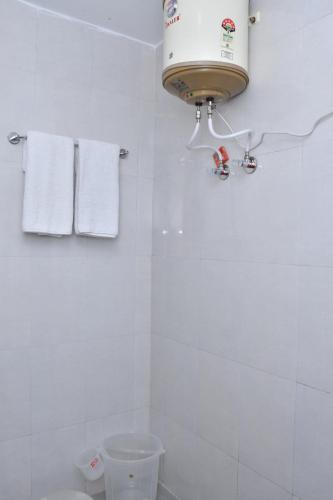 a bathroom with a toilet and a water heater at The Crown in Dharamshala