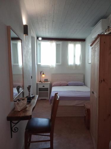 a bedroom with a bed and a table and a chair at Elva House in Panormos