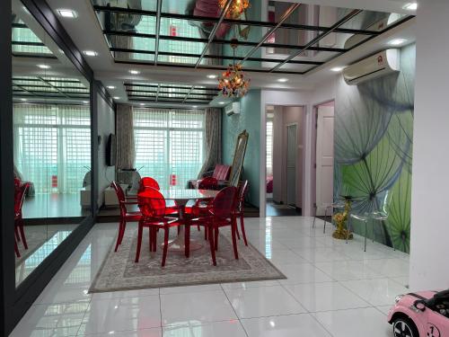 a dining room with red chairs and a table at 3BR Condo at Gelugor by Hana Suite in Jelutong