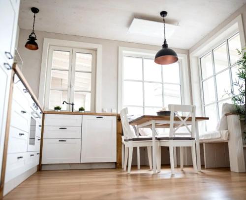 a kitchen with a table and chairs and windows at MoMare- Strandhäuser am Hainer See - Neukieritzsch - KleineSeensucht - SeeSchlösschen - GlücksKind in Neukieritzsch