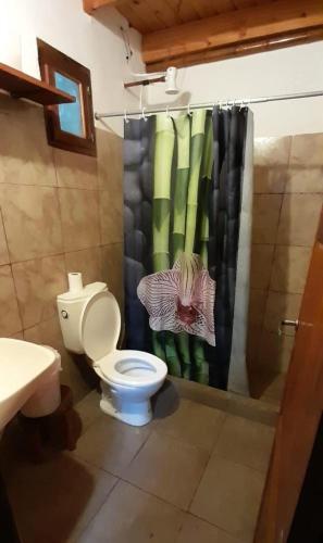 a bathroom with a toilet and a shower curtain at Chacra Ñasaindy in Puerto Wanda