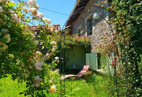 une maison ancienne avec une porte verte dans un jardin dans l'établissement Glamping Room The Rose Garden with own garden - external shower & toilet and kitchen, à Mazières