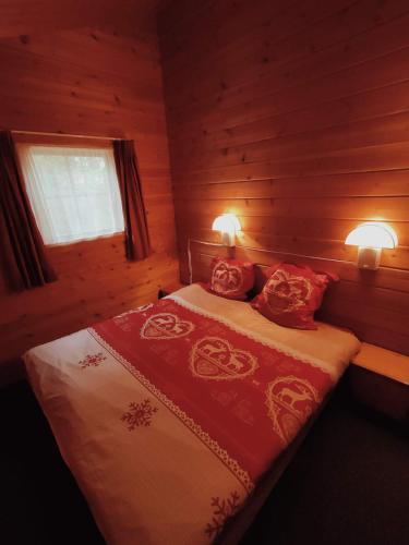 une chambre avec un lit avec deux oreillers rouges dans l'établissement Sherlock Home, à Mauroux