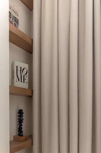 a white curtain in a room with a shelf at Garden & Pool Access Studio in Sharjah
