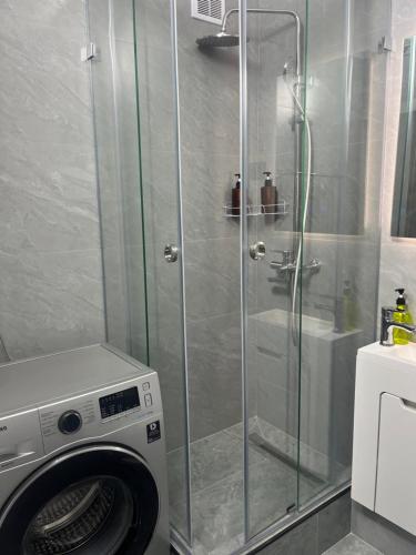 a washing machine in a bathroom with a shower at 1-ная Квартира Орбита in Rakhat