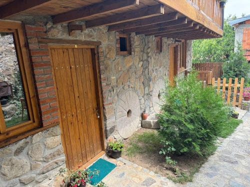 a stone house with a wooden door in a yard at Villa Old House BN in Bitola