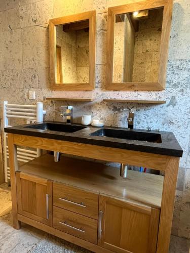 une cuisine avec un évier et des armoires en bois dans l'établissement La Maison Bois, Salavas, Vallon Pont D'Arc, à Salavas