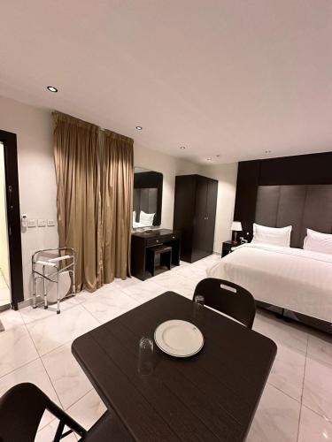 een hotelkamer met een bed, een tafel en een bureau bij شقق درر رامه للشقق المخدومة 12 in Riyad