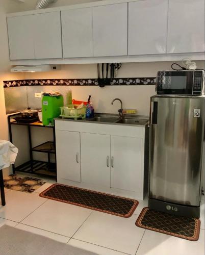 a kitchen with white cabinets and a sink and a counter at Riverside 2 Bedroom 5 Beds in Naga