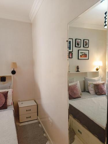 a mirror in a bedroom with a bed at Charmant appartement équipé près de Guéliz in Marrakech
