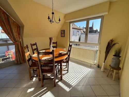 une salle à manger avec une table et des chaises et une fenêtre dans l'établissement Gîte Mamie Berthe, à Sélestat