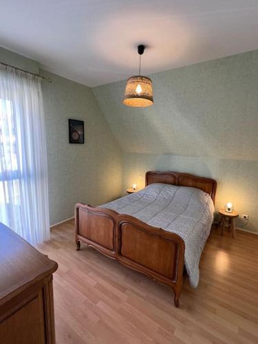 une chambre avec un lit en bois dans une pièce dans l'établissement Gîte Mamie Berthe, à Sélestat