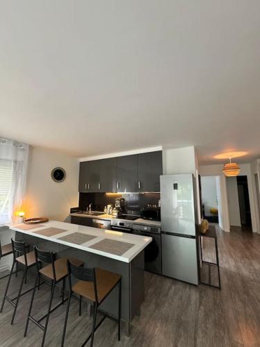 une cuisine avec une table, des chaises et un réfrigérateur dans l'établissement Magnifique Appartement, à Saint-Maur-des-Fossés