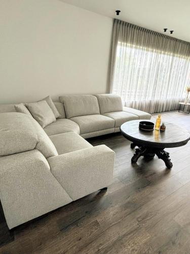 a living room with a couch and a coffee table at B&B Casa Roman & Vakantiewoning voor 1 pers tot max 32 personen in Zonhoven