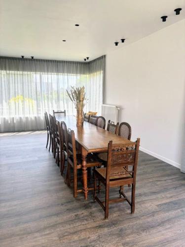 a wooden table and chairs in a room at B&B Casa Roman & Vakantiewoning voor 1 pers tot max 32 personen in Zonhoven