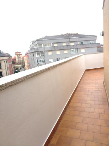 a balcony with a view of a building at Ático en la Playa de Cangas in Cangas de Morrazo
