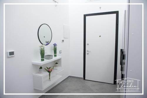 a white room with a door and a mirror at A casa di Claudia in Brindisi
